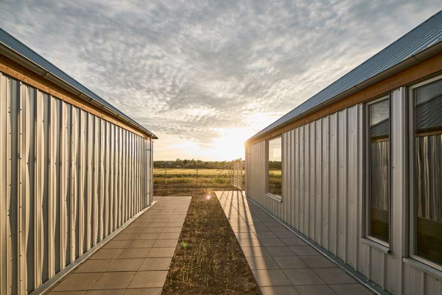 The rib sheets of Jordbærmarken create a rural atmosphere and inspire children to play outdoors, Børnehuset Jordbærmarken, Rodskovvej 59, 8543 Hornslet
